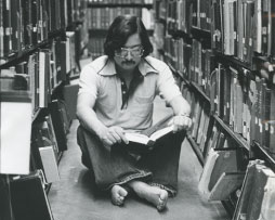 Photo of a man sitting on the floor in a library
